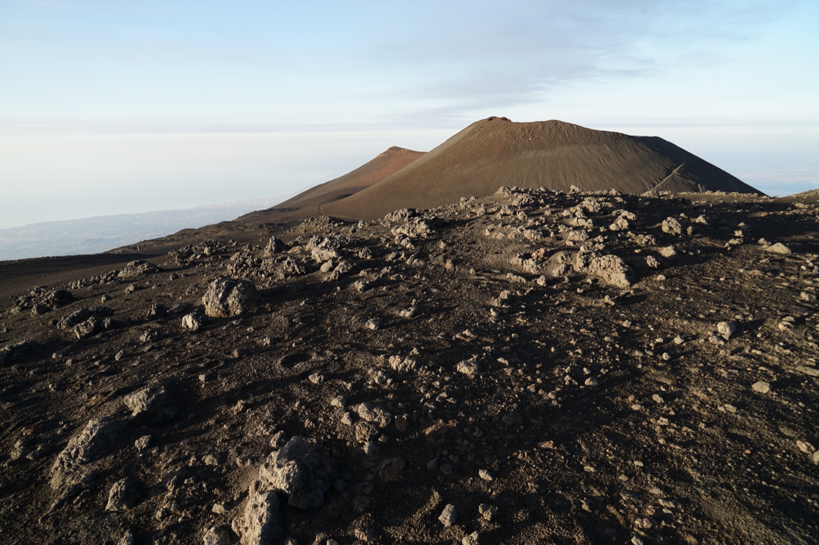 Walkers on the trail towards the summit craters of Mount Etna